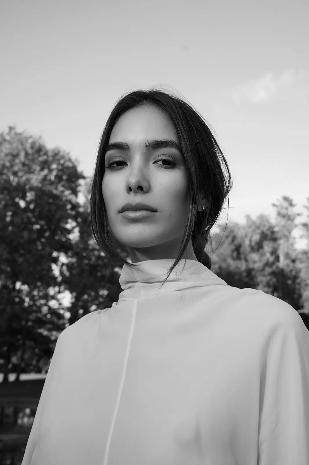 Black-and-white portrait of Sharon outdoors.